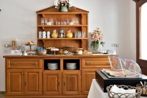 a kitchen with a wooden hutch with dishes on it at Hotel Goloritzé in Baunei