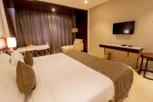 a hotel room with a large bed and a desk at Visthara inn - Comfort Stay in Krishnagiri