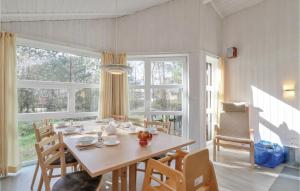 a dining room with a table and a large window at Dünenpark 16 - Dorf 6 in Priwall