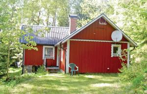 a red barn with a chair in front of it at Nice Home In Ryd With 2 Bedrooms And Sauna in Ryd