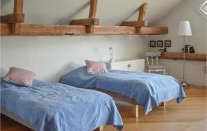 twee bedden in een kamer met blauwe lakens bij Lovely Home In Sankt Anna With Kitchen in Sankt Anna