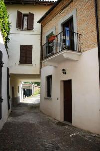 an alley with a building with a balcony and a door at Casa Lidia locazione breve in Agliano Terme