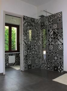a bathroom with a black and white tile wall at Casa Lidia locazione breve in Agliano Terme