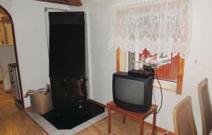 a tv sitting on a table in a living room at Nice Home In Ryd With 2 Bedrooms And Sauna in Ryd