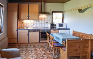 una cucina con tavolo, sedie e piano di lavoro di Cozy Home In Sellerich With Kitchen a Sellerich