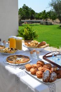 a table topped with plates of pastries and pies at Masseria Vignenove in Uggiano la Chiesa