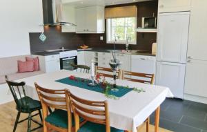 a kitchen with a white table with chairs and a dining room at Holiday Home Sandåkra Vetlanda in Vetlanda
