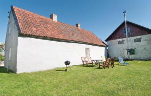 un edificio blanco con sillas y una parrilla en el patio en Gorgeous Home In Klintehamn With Kitchen, en Hejde
