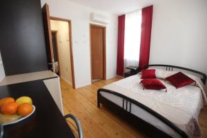 a bedroom with a bed with red pillows and a bowl of fruit at Haifa Guest House in Haifa