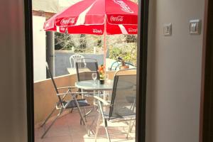 a table and chairs under an umbrella on a balcony at Haifa Guest House in Haifa