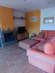 sala de estar con 2 sofás rojos y chimenea en Casa EL PORT DE LA SELVA, en Port de la Selva