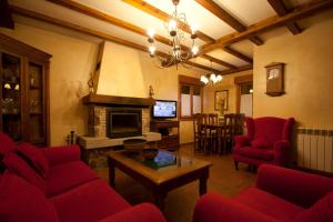 - un salon avec des chaises rouges et une cheminée dans l'établissement Casa de la Yaya, à Hoyos del Espino