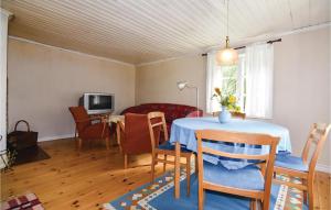 sala de estar con mesa, sillas y TV en Stunning Home In Sffle With Sauna, en Säffle