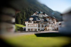 a large white building with a black roof at Hotel Tanzer in Ischgl