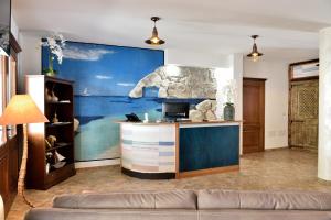 a living room with a large painting on the wall at Hotel Goloritzé in Baunei +32 photos