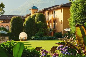 ein Resort mit einer Liegewiese mit Stühlen und Bäumen in der Unterkunft Giardino Ascona in Ascona
