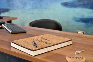 a notebook sitting on top of a desk with a pen at Hotel Goloritzé in Baunei