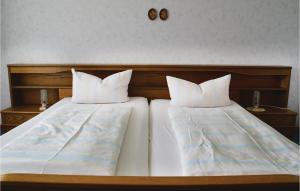 twee bedden met witte kussens naast elkaar bij 3 Bedroom Awesome Apartment In Breuna in Breuna