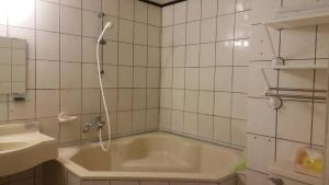 een badkamer met een bad en een wastafel bij Zhiben Hot Spring Hsiao Hotel in Wenquan
