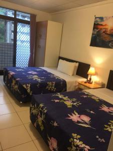 pokój hotelowy z 2 łóżkami z niebieską pościelą w obiekcie Zhiben Hot Spring Hsiao Hotel w mieście Wenquan