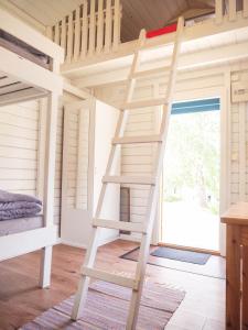 a ladder in a tiny house bedroom with a bunk bed at Björkbackens Stugby i Vimmerby in Vimmerby