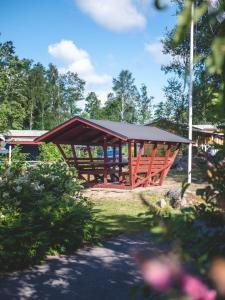 un pabellón de madera con techo en un parque en Björkbackens Stugby i Vimmerby, en Vimmerby