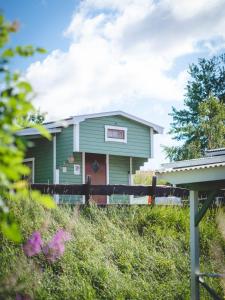 una casa verde en la cima de una colina en Björkbackens Stugby i Vimmerby, en Vimmerby