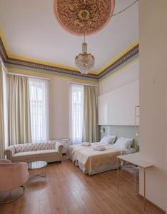 a bedroom with a bed and a couch and a chandelier at Agora Residence in Chios