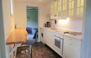 a kitchen with a counter and a table and a sink at Stunning Home In Borgholm With Kitchen in Borgholm