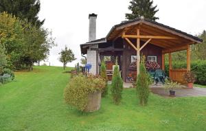 a gazebo with a table and a bench in a yard at Holiday Home Alpirsbach - 08 in Marschalkenzimmern