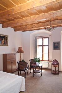 1 dormitorio con 1 cama, mesa y sillas en Hotel U Zlatého Lva en Havlickuv Brod