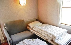 un letto e una sedia in una stanza con finestra di Kvighult a Forsvik