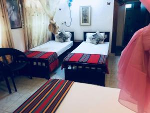- une chambre avec 2 lits et 2 chaises dans l'établissement Joseph Family Villa, à Negombo