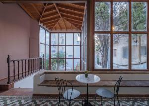 a room with a table and chairs and windows at Agora Residence in Chios