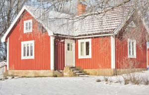 uma casa vermelha com neve no chão em Beautiful Home In lmhult With 1 Bedrooms em Liatorp