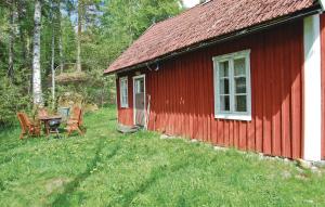 una cabina rossa con tavolo e sedie di fronte di Kvighult a Forsvik