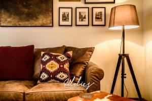 ein Wohnzimmer mit einem braunen Sofa und einer Lampe in der Unterkunft Eddie’s Design Apartments in Wien