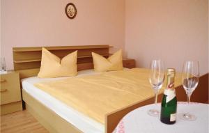 een slaapkamer met een bed met twee wijnglazen op een tafel bij 3 Bedroom Awesome Apartment In Breuna in Breuna