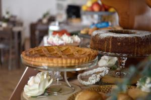a buffet with cakes and pies on a table at Hotel Goloritzé in Baunei
