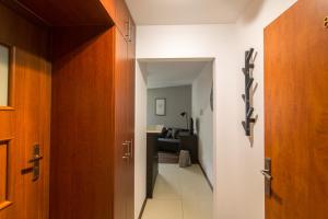pasillo con puertas de madera y sala de estar. en Krynica Apartamenty Apartament Studio Centrum 89, en Krynica-Zdrój