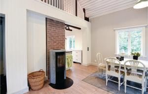 une salle à manger avec une cheminée et une table avec des chaises dans l'établissement Lovely Home In lgars With Kitchen, à Älgarås
