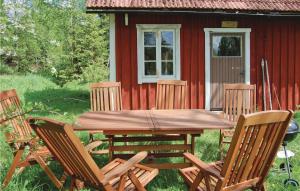 a wooden table and chairs in front of a red cabin at Kvighult in Forsvik
