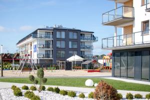 an apartment building with a playground in front of it at Blu Apartments in Sarbinowo