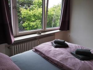 a bed with two pillows on it in a room with two windows at City Apartment Bahnhofnah in Kiel