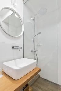 y baño con lavabo blanco y espejo. en Blubini Heritage House, en Rovinj