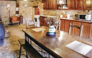 Beaulieu-sur-SonnetteにあるAmazing Home In Beaulieu Sur Sonnette With 2 Bedroomsのキッチン(花瓶付きの木製テーブル付)