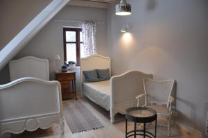 a bedroom with a bed and two chairs and a table at Zakątek Sary in Jonkowo