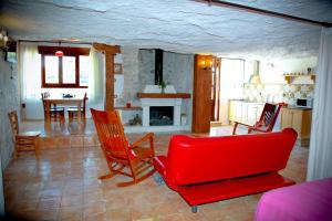 a living room with a red couch and a table at Casa Rural La Bodeguilla in Alcalá del Júcar