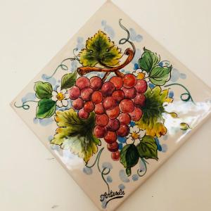 a painting of a bunch of grapes on a plate at Casa FERRARA in Taormina +8 photos