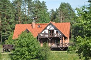 a house with an orange roof in a forest at Zakątek Sary in Jonkowo